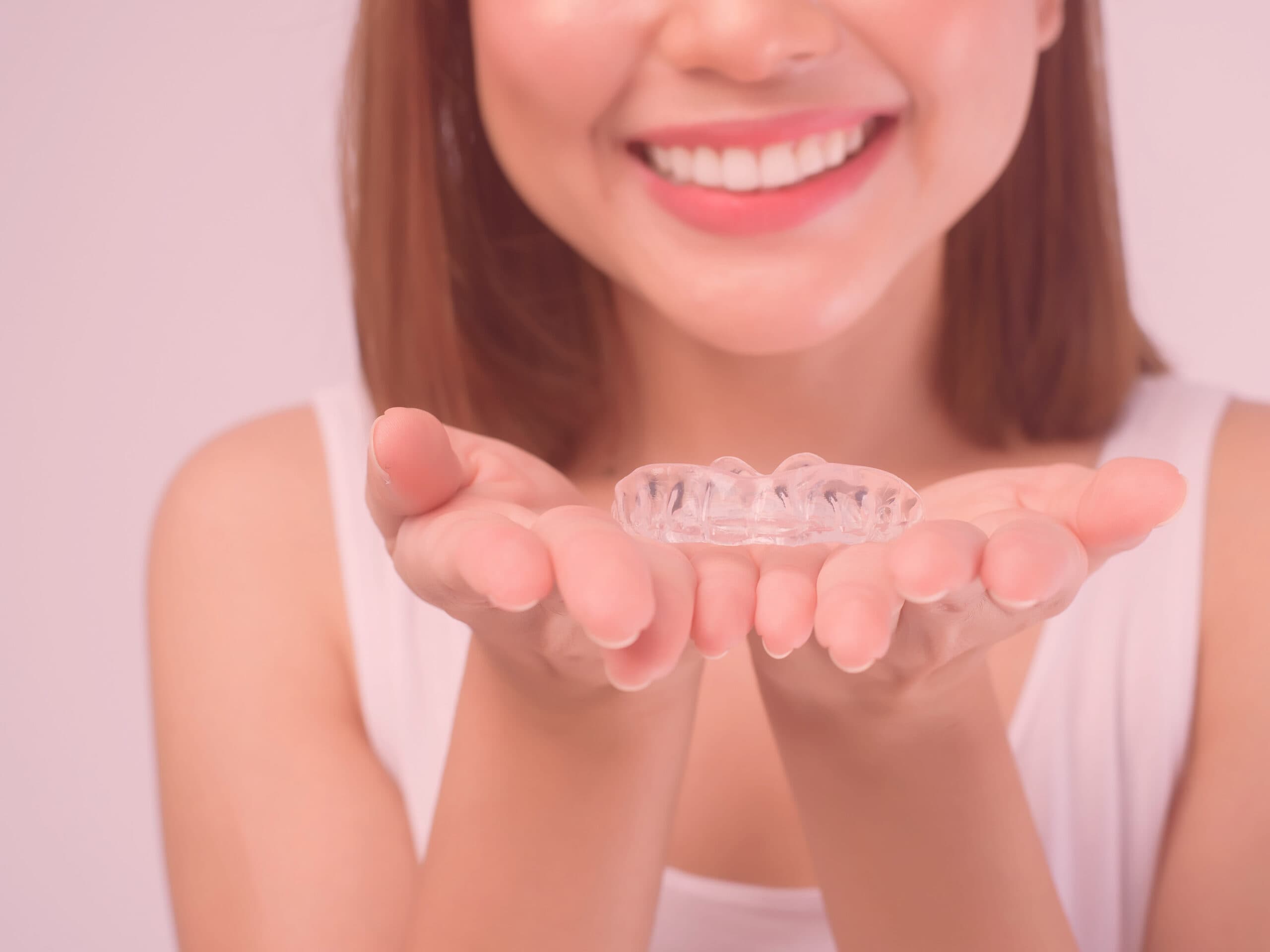 Femme tenant un aligneur transparent dans ses mains